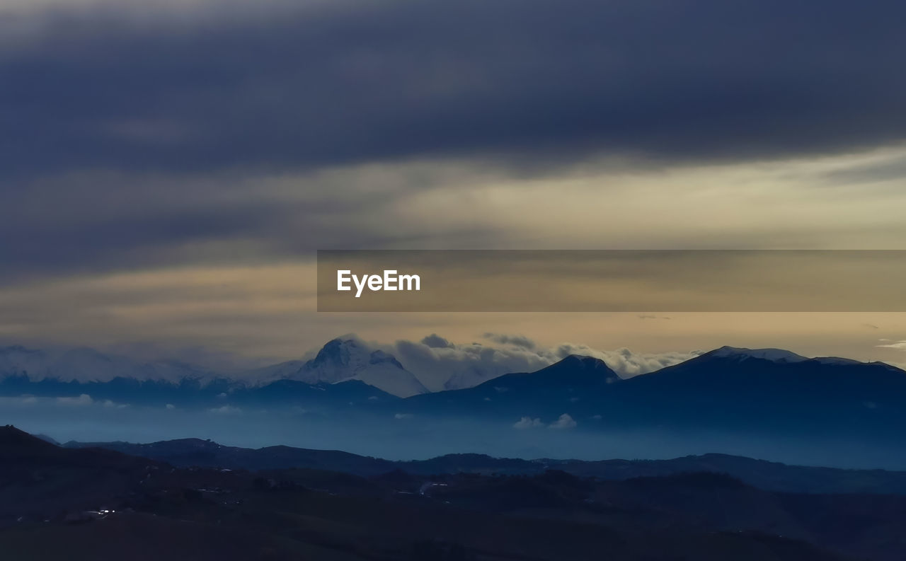 Scenic view of silhouette mountains against sky during sunset