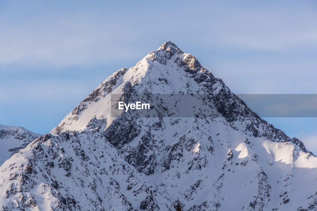 Low angle view of snowcapped mountain against sky