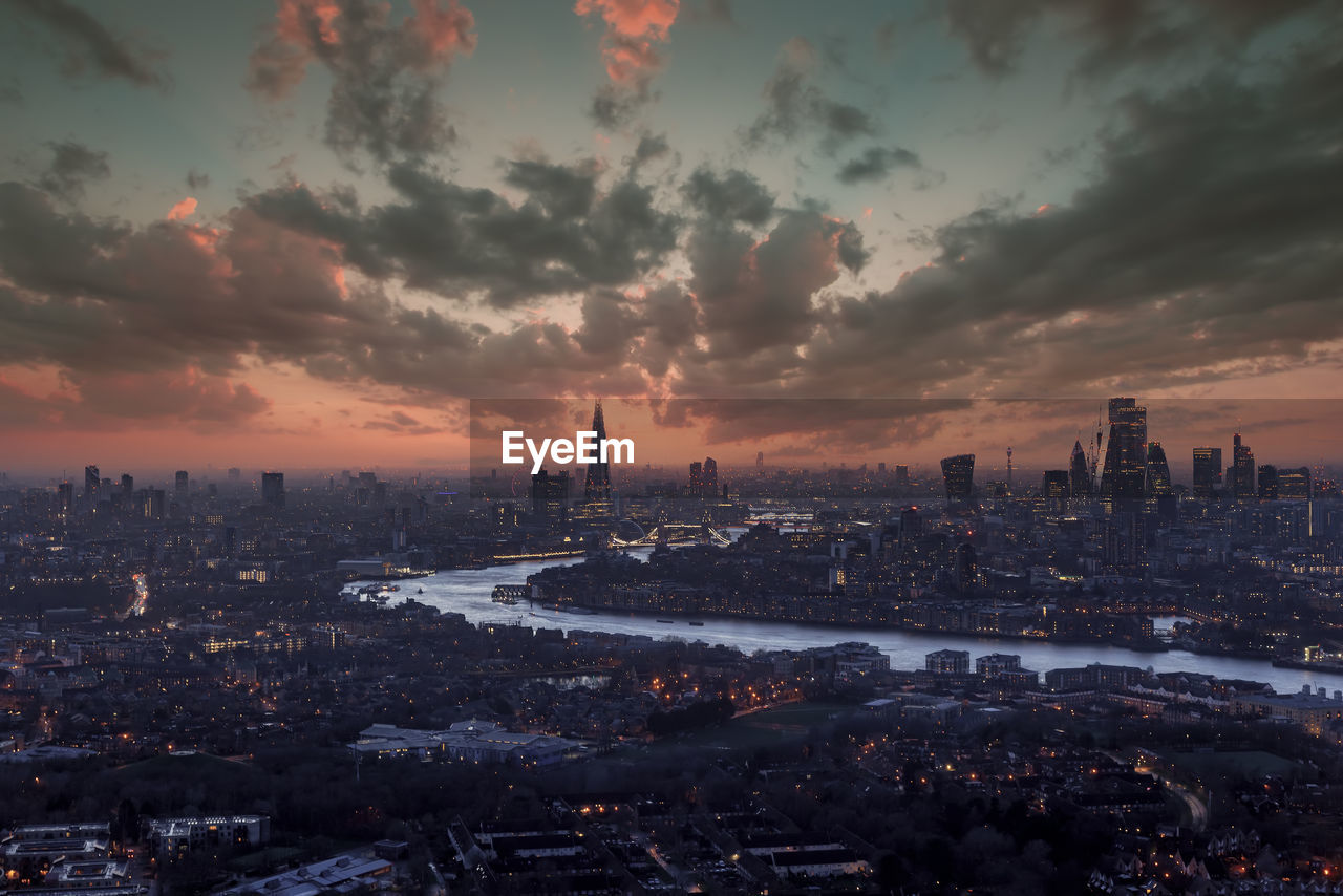 High angle view of illuminated cityscape against sky during sunset