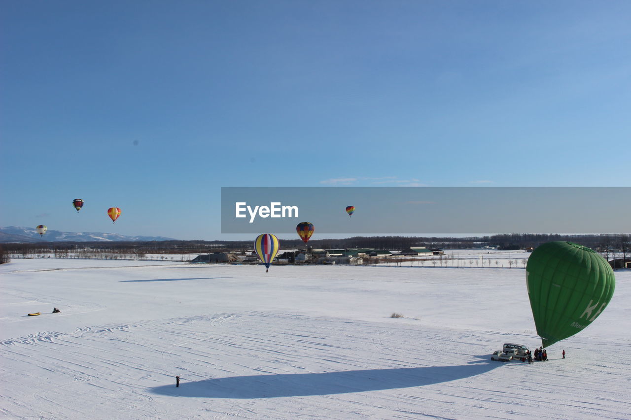 Hot air balloon flying over land against sky