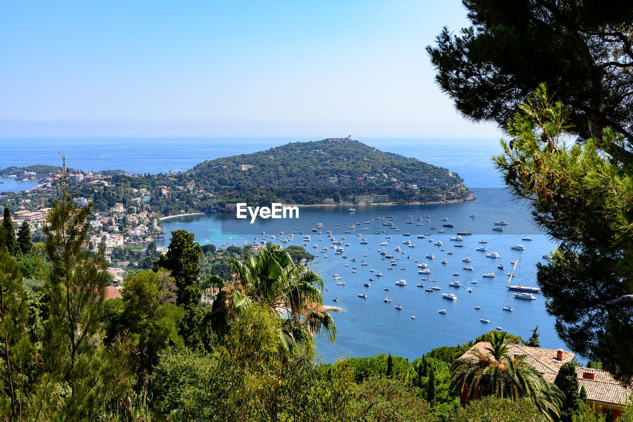 Boats moored in sea against clear sky