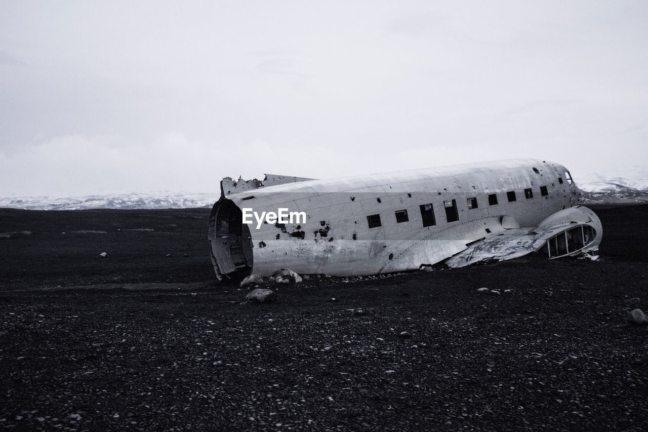 Side view of an abandoned airplane on landscape