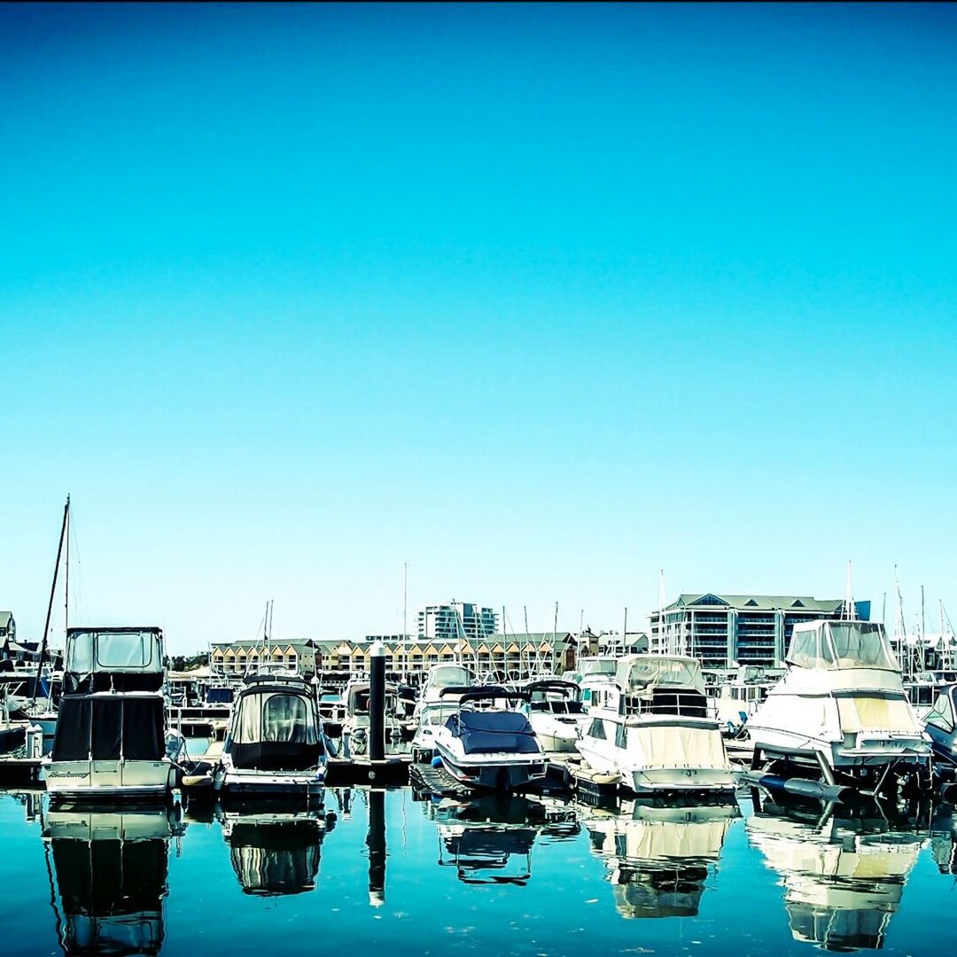 BOATS IN HARBOR AGAINST CLEAR BLUE SKY