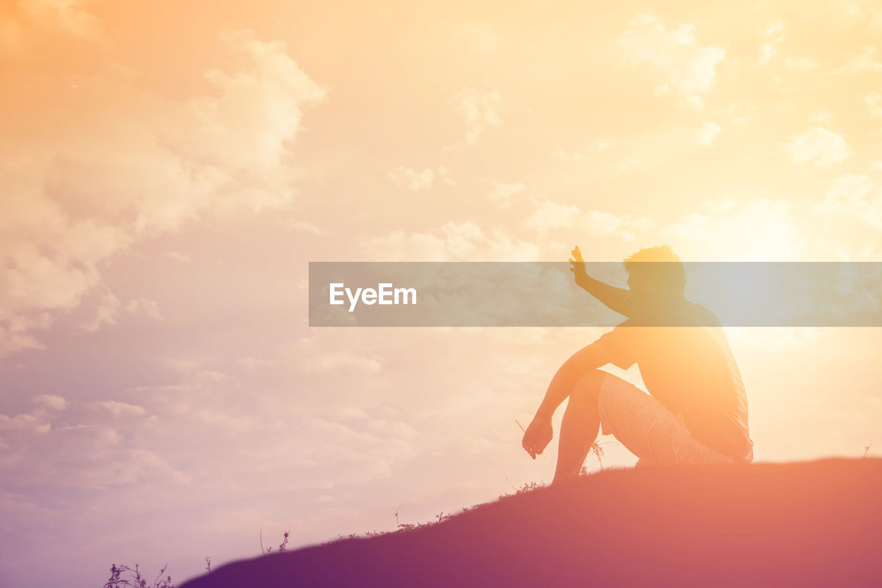 LOW ANGLE VIEW OF SILHOUETTE MAN STANDING AGAINST SKY