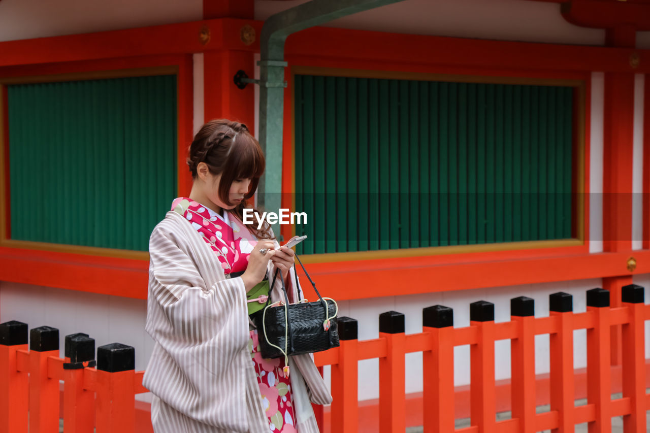 FULL LENGTH OF GIRL HOLDING RED UMBRELLA