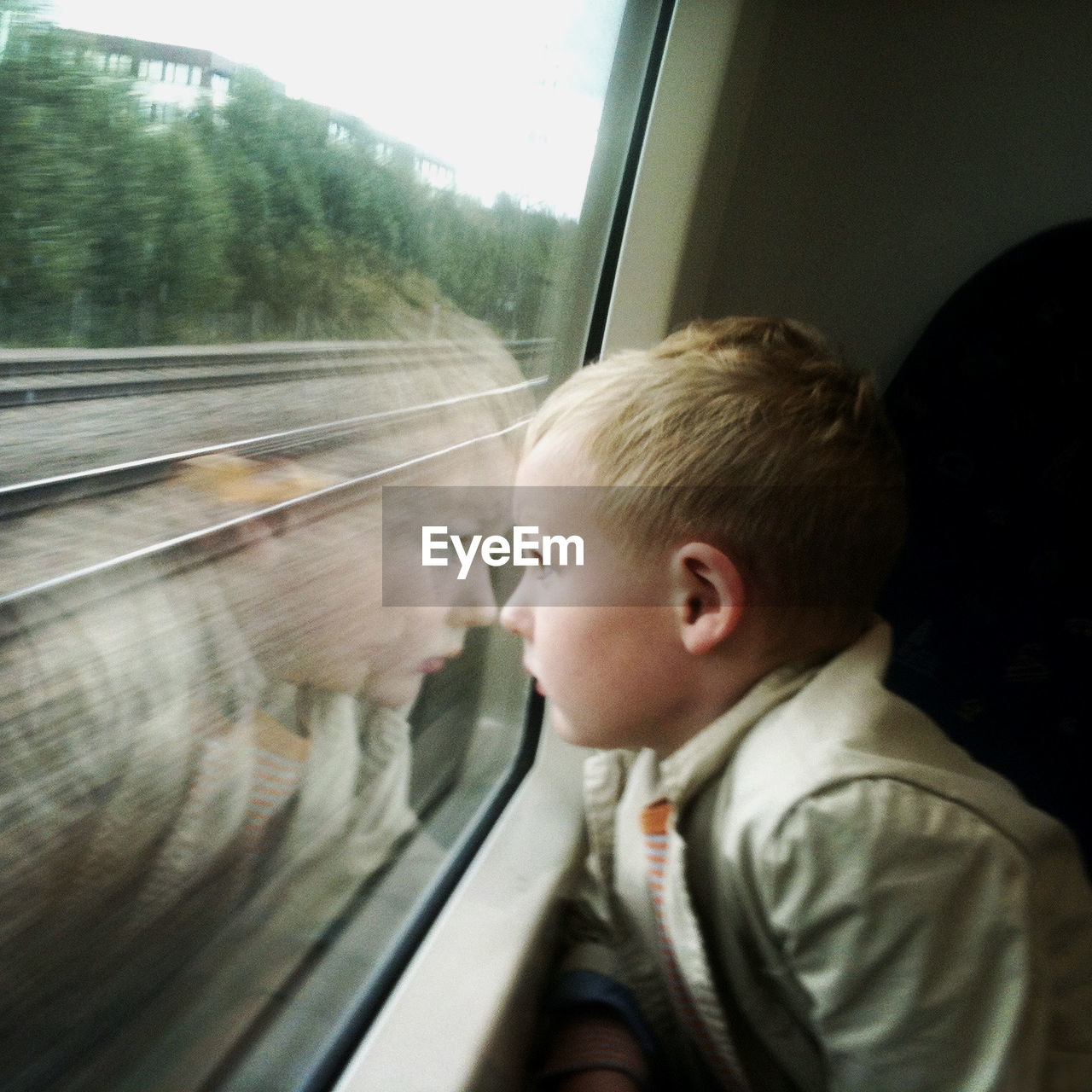 Boy looking through window in train