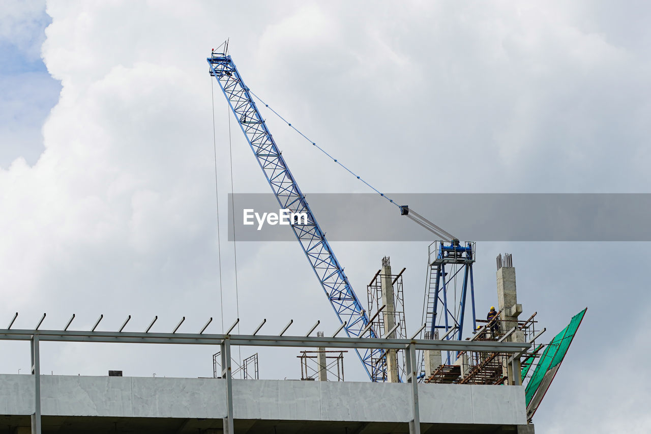 low angle view of cranes against sky