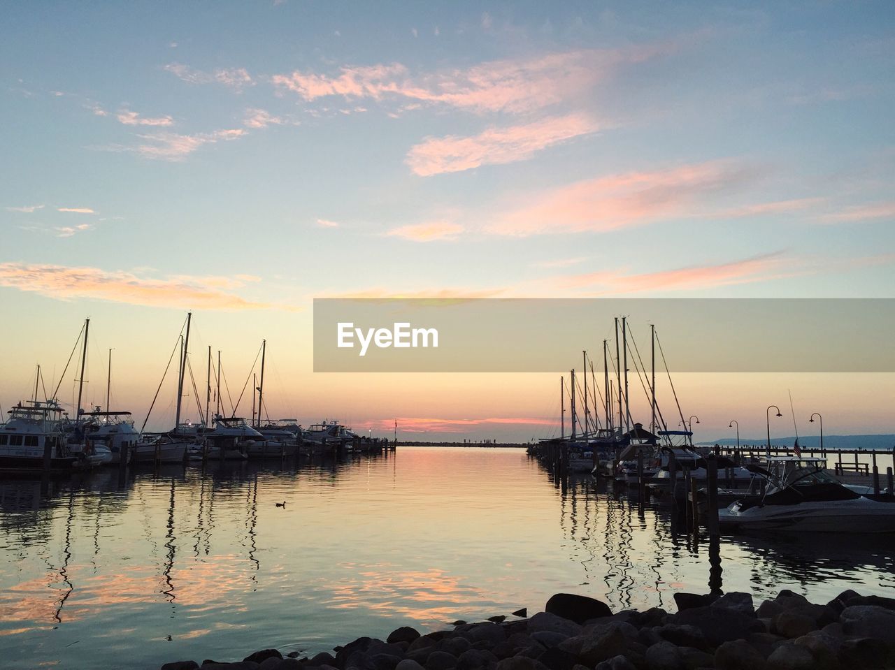 Boats moored in sea at sunset