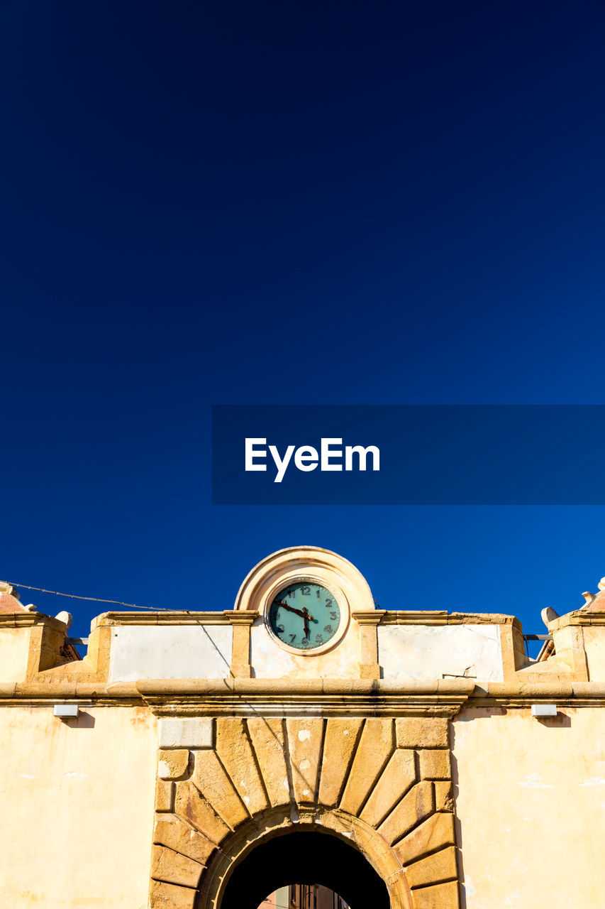 LOW ANGLE VIEW OF CLOCK AGAINST CLEAR SKY