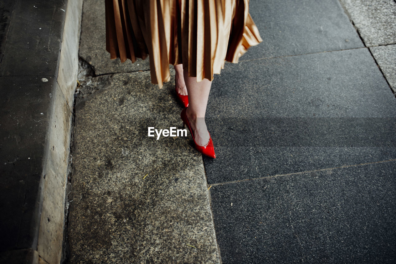 Low section of woman walking on street