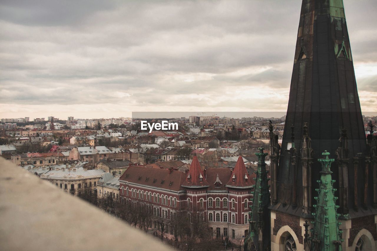 View of cityscape against cloudy sky