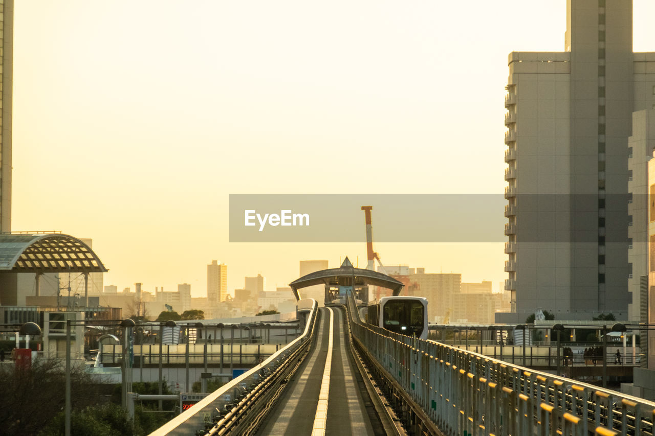 Bridge in city against clear sky