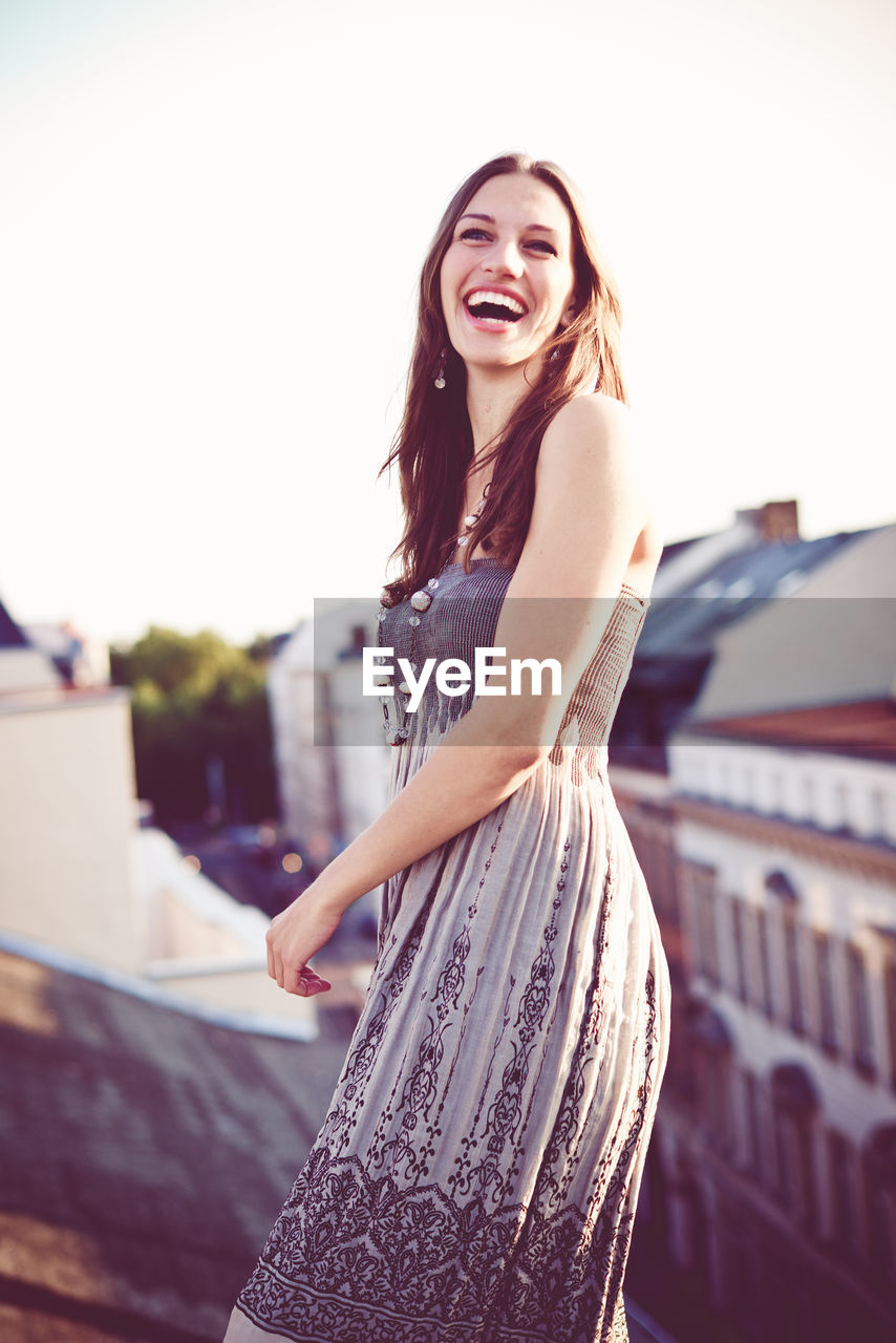 Happy woman laughing on rooftop 