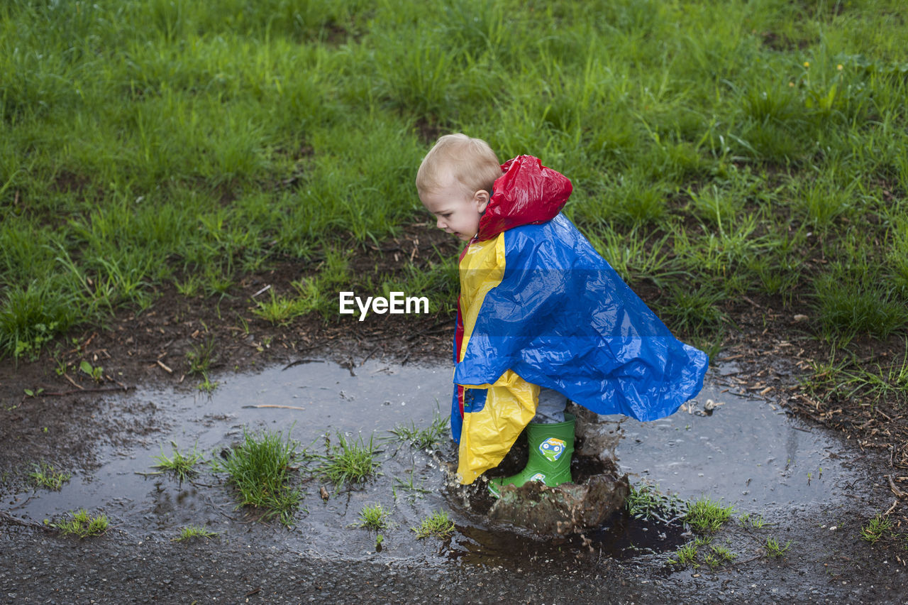 Boy jumping in the puddle