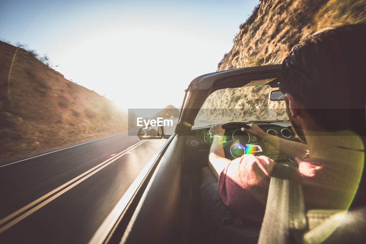 REAR VIEW PORTRAIT OF MAN DRIVING CAR