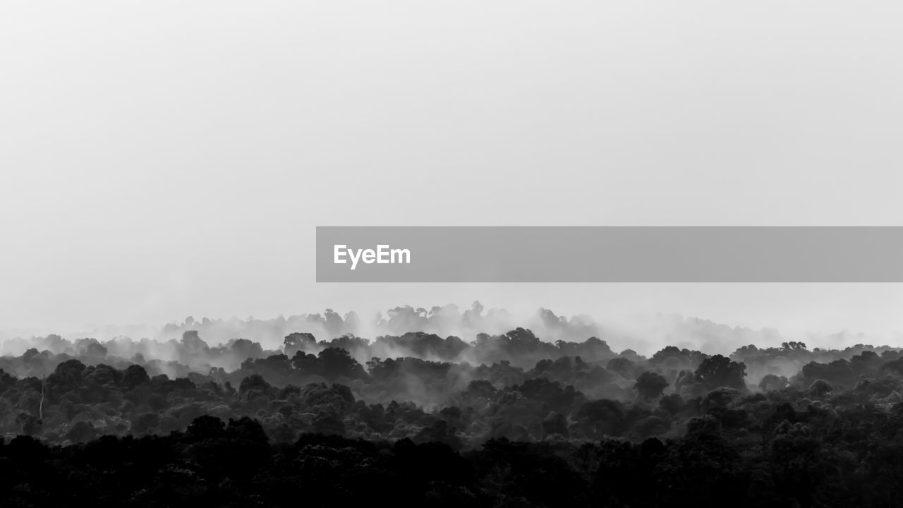 Scenic view of trees and mountains against sky