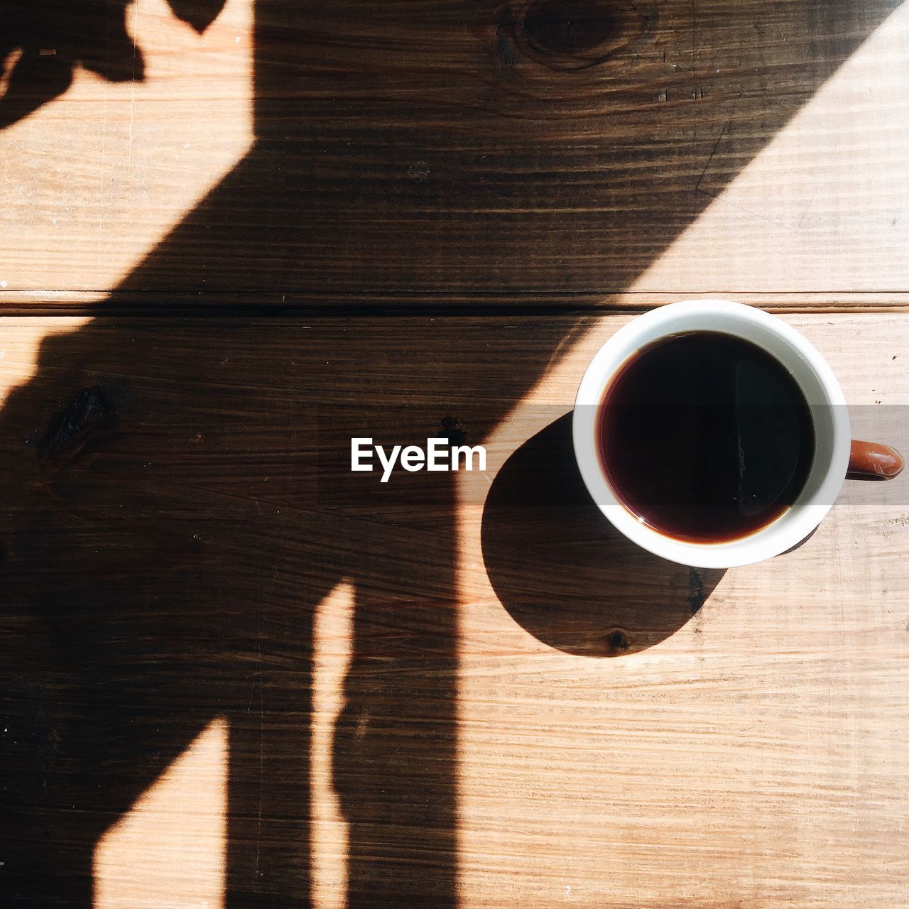 High angle view of black coffee on wooden table