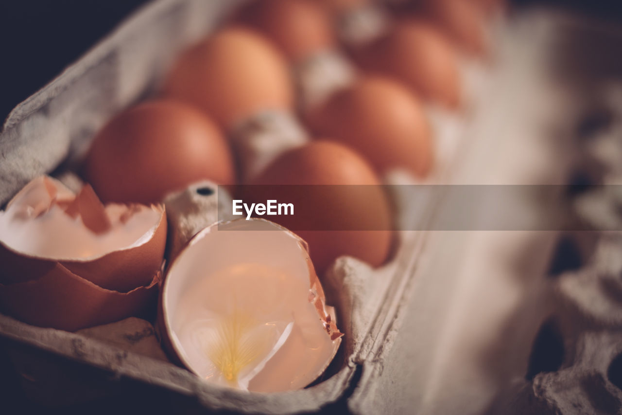 Close-up of cracked eggs in carton