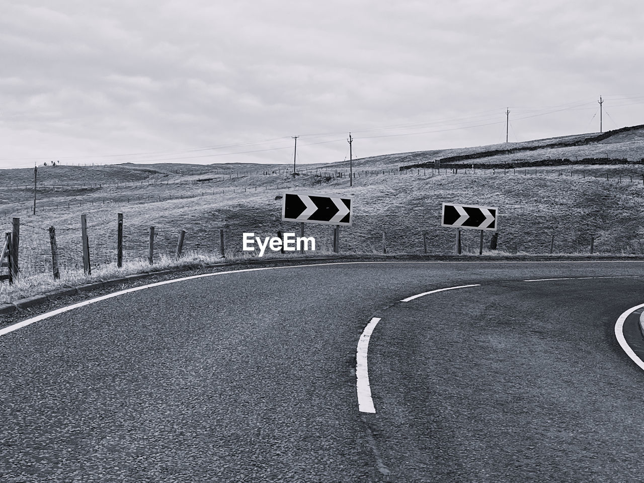 road, transportation, monochrome, black and white, sky, sign, asphalt, symbol, road marking, cloud, marking, nature, monochrome photography, day, no people, race track, architecture, road sign, infrastructure, lane, environment, outdoors, built structure, tarmac, city, guidance, the way forward, empty road, street, landscape, highway, arrow symbol