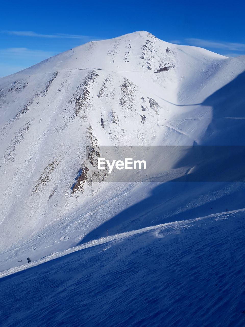 Scenic view of snowcapped mountain against blue sky