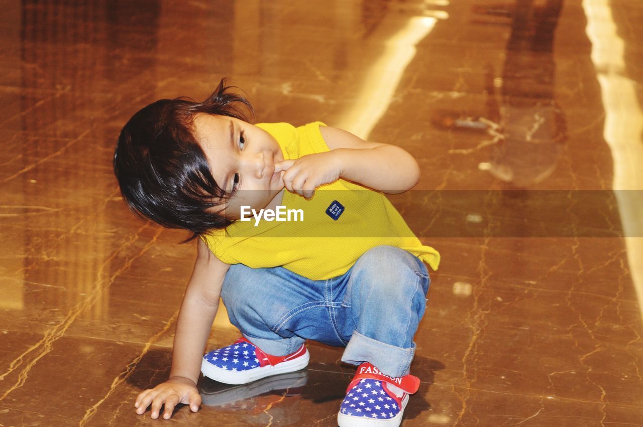 HIGH ANGLE VIEW OF WOMAN SITTING ON FLOOR