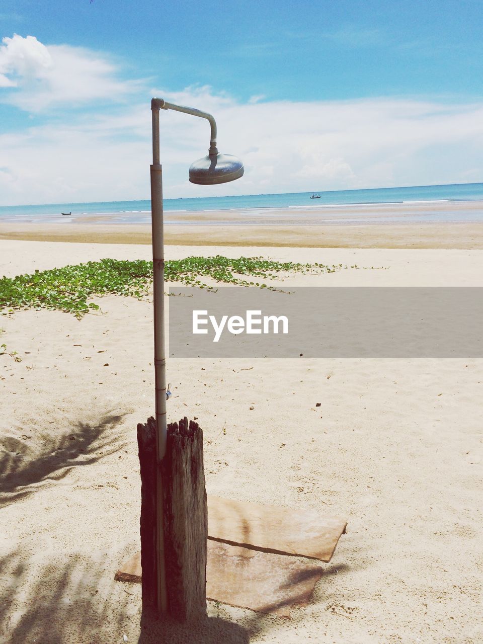 Scenic view of calm beach against blue sky