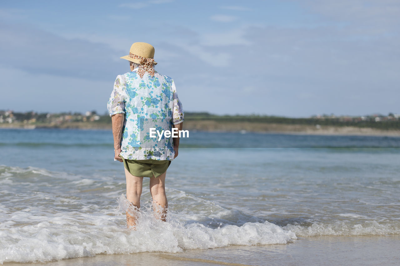 Back view of senior woman at seashore