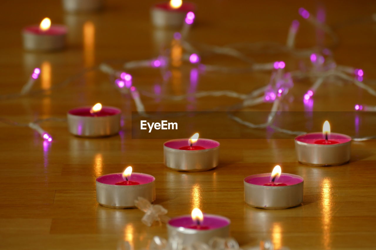 CLOSE-UP OF LIT CANDLES IN TEMPLE