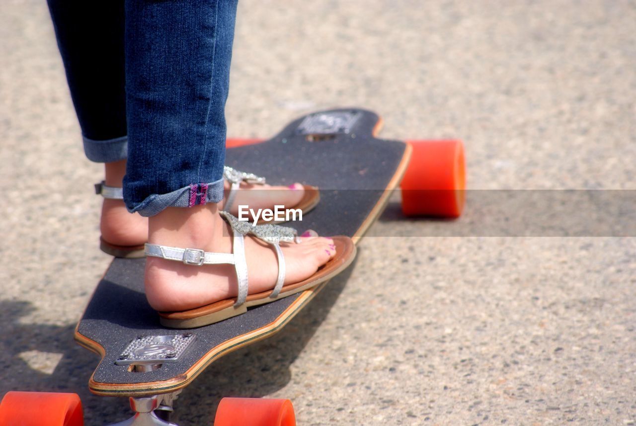 Low section of woman standing on skateboard