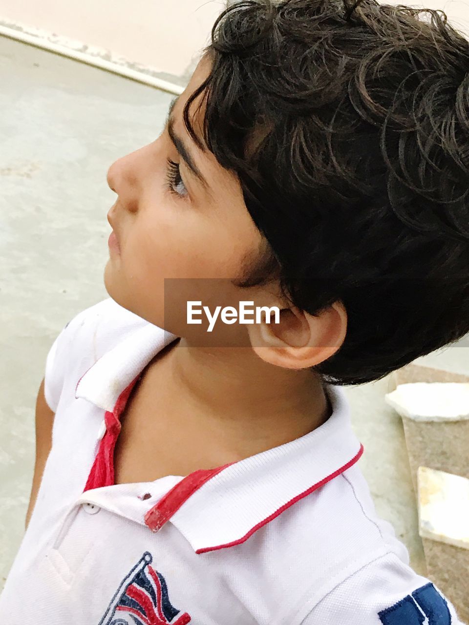 High angle view of thoughtful boy looking away while standing outdoors