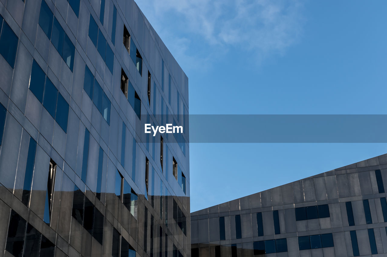 LOW ANGLE VIEW OF MODERN BUILDING AGAINST CLEAR BLUE SKY