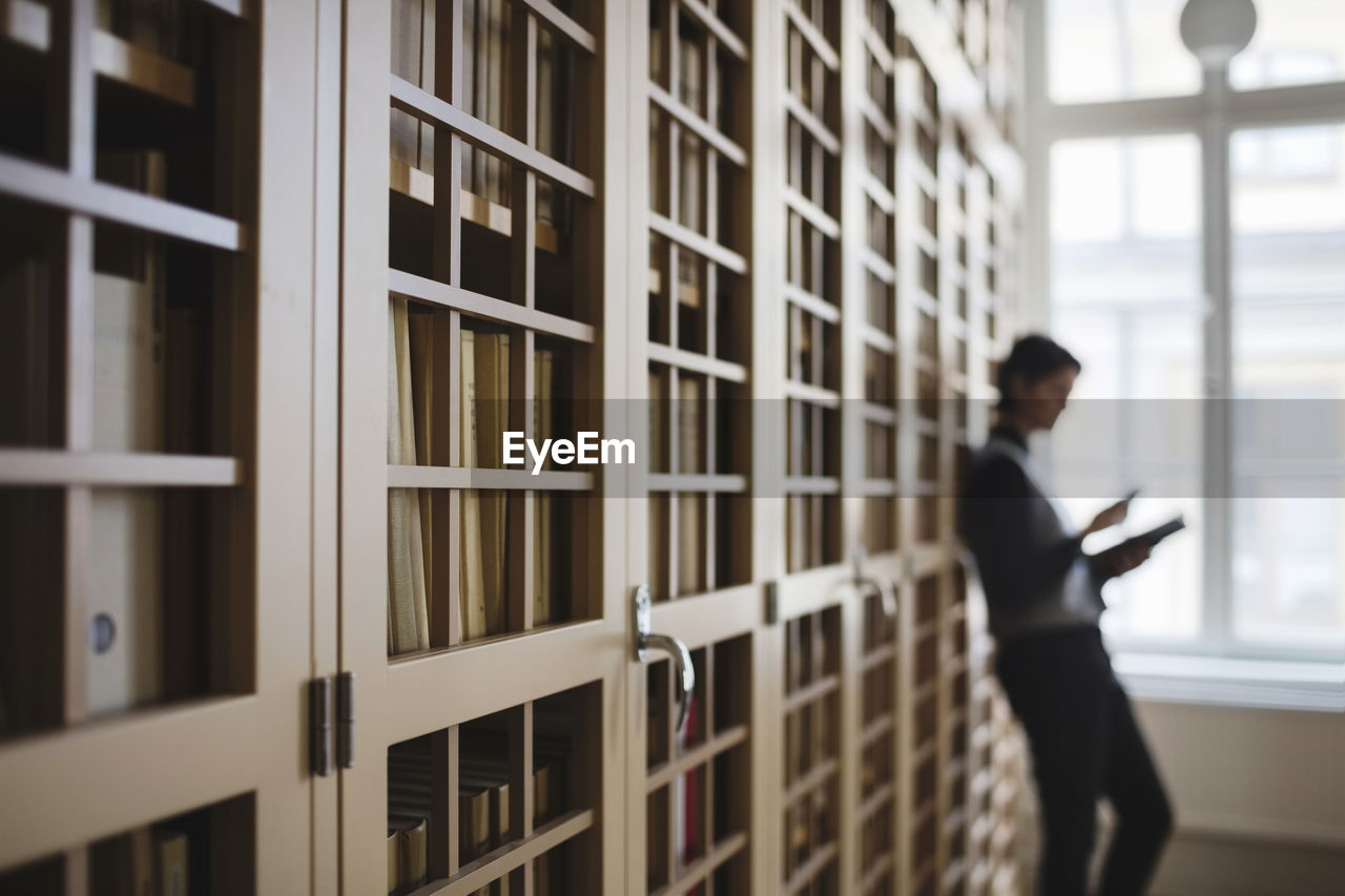 Female lawyer leaning on bookshelf in library