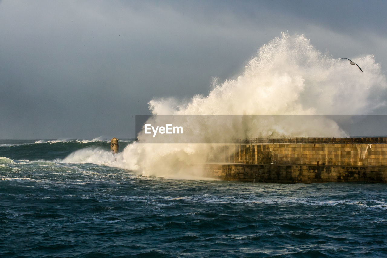 Waves breaking against pier