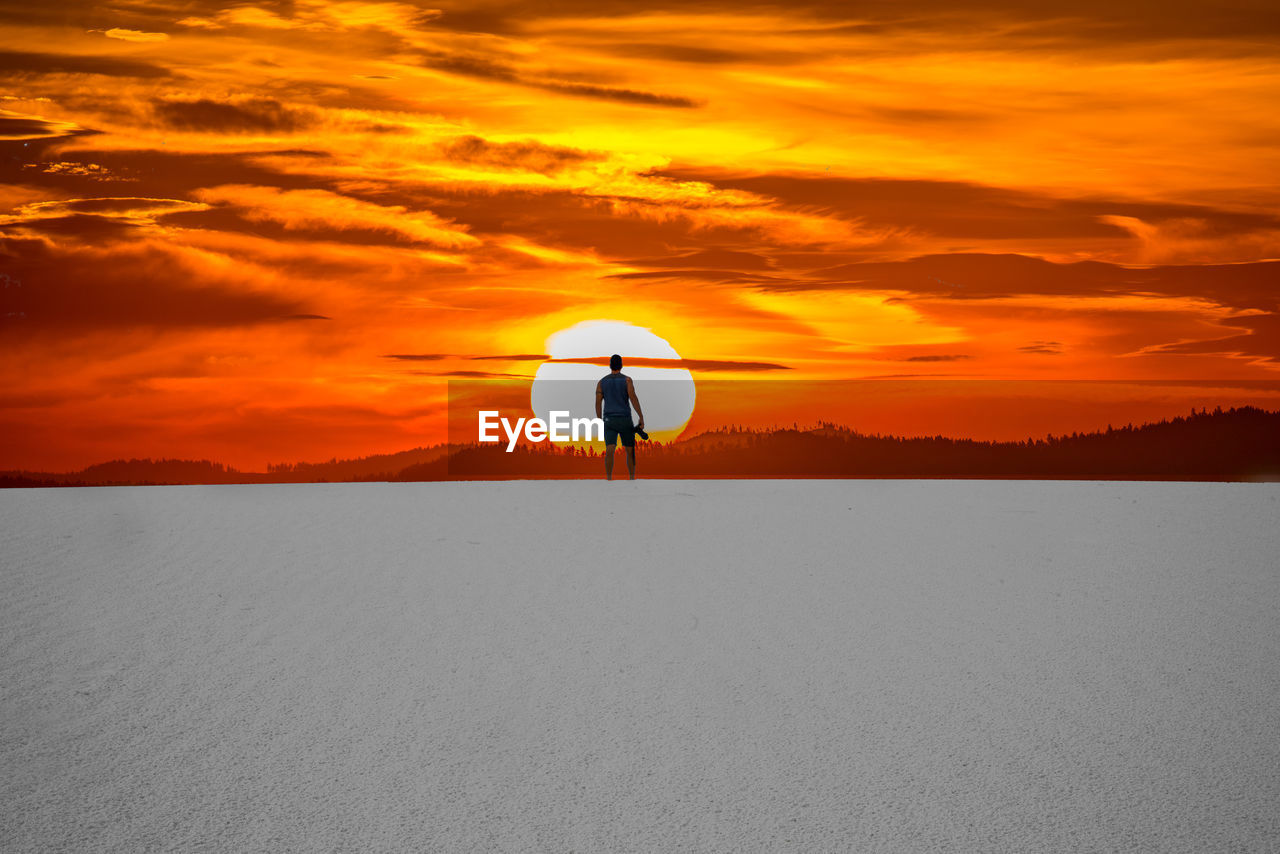 SCENIC VIEW OF LAND AGAINST ORANGE SKY