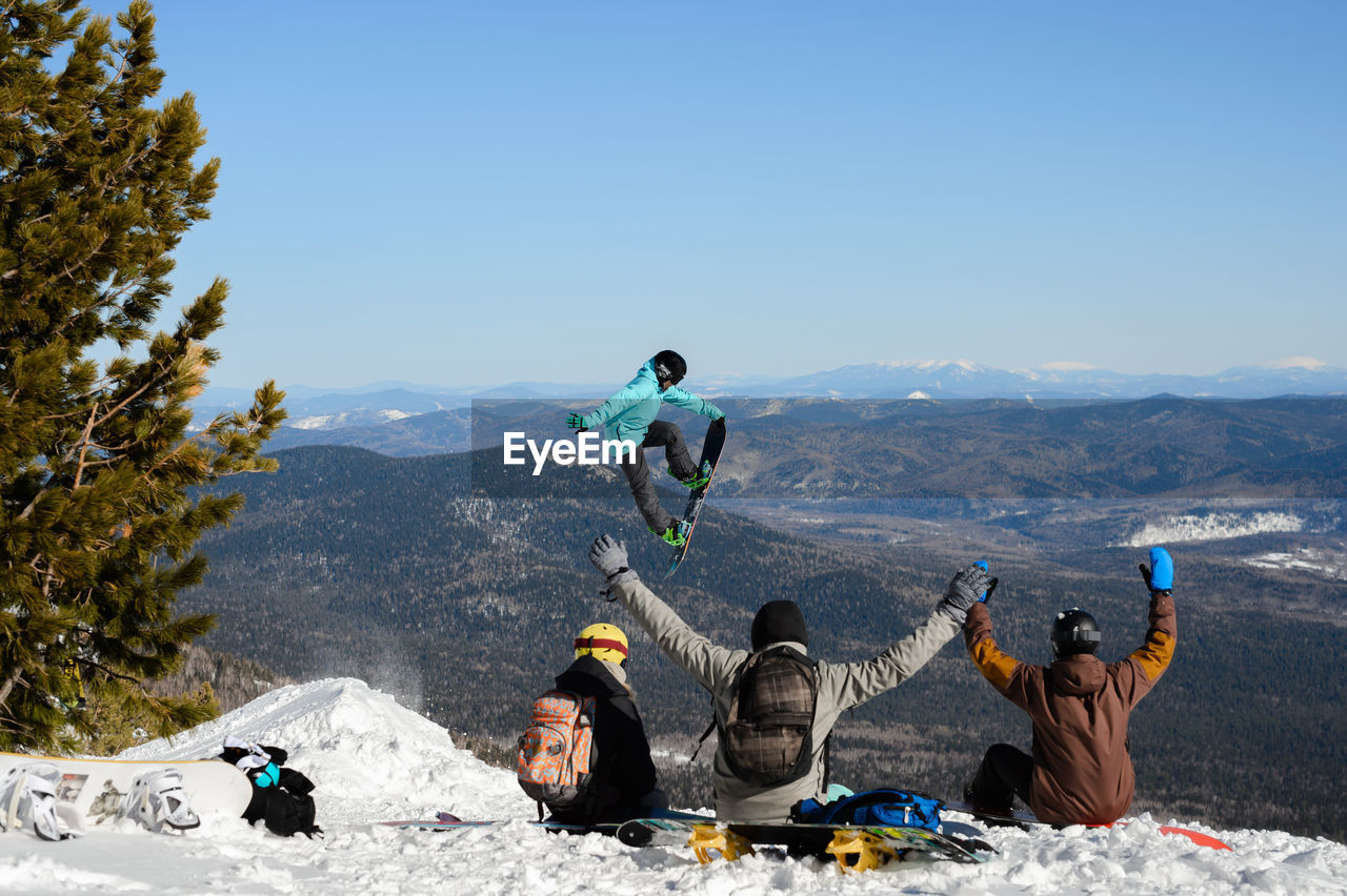 Group of people on mountain range against sky