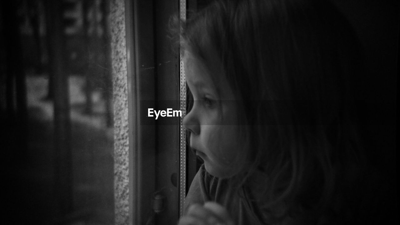 CLOSE-UP OF WOMAN LOOKING THROUGH WINDOW