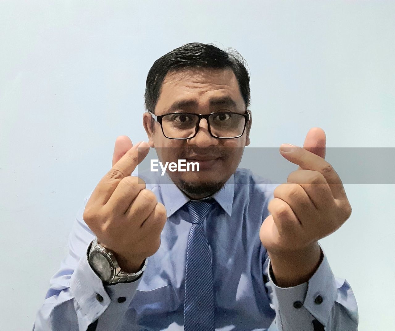 eyeglasses, one person, glasses, men, portrait, adult, gesturing, finger, person, looking at camera, businessman, sign language, front view, studio shot, business, hand, indoors, thumbs up, hand sign, emotion, headshot, button down shirt, waist up, pointing, smiling, communication, human face, business finance and industry, necktie, success, menswear, facial expression, showing, occupation, white background, professional occupation, mature adult