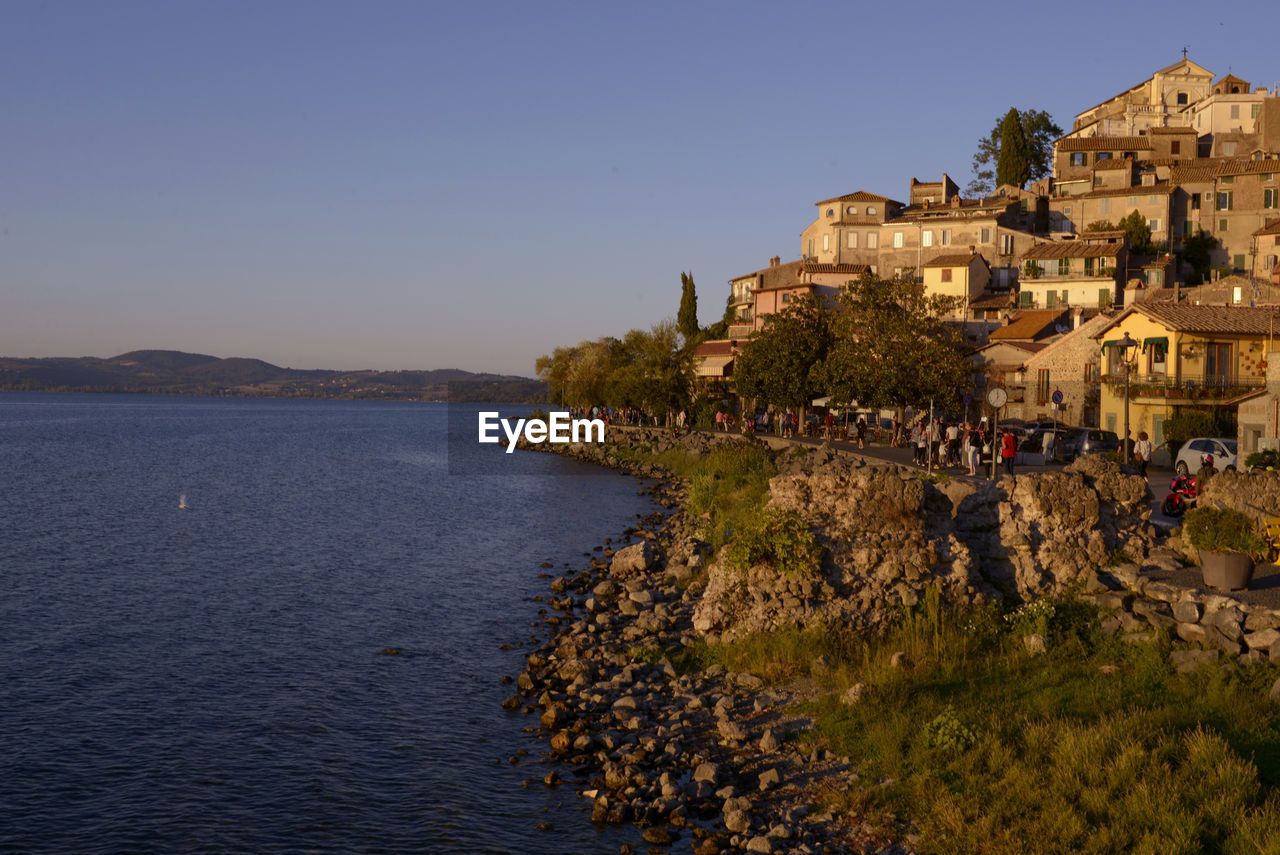 Scenic view of sea and buildings against clear blue sky