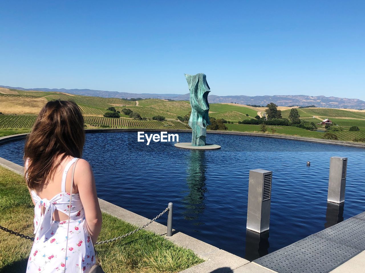 REAR VIEW OF WOMAN LOOKING AT OBSERVATION POINT AGAINST SKY