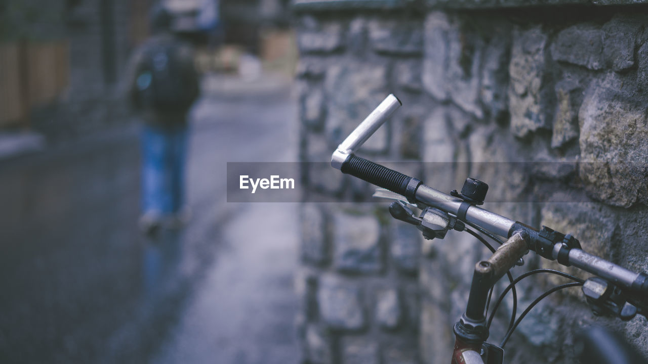 CLOSE-UP OF BICYCLE PARKED AGAINST WALL