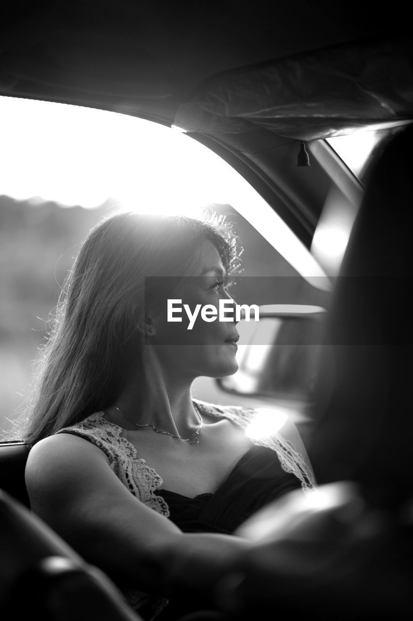 Woman looking away while sitting in car