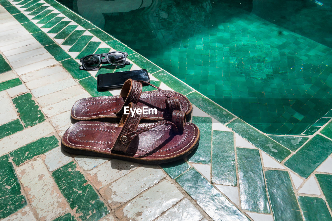 High angle view of personal accessories at poolside