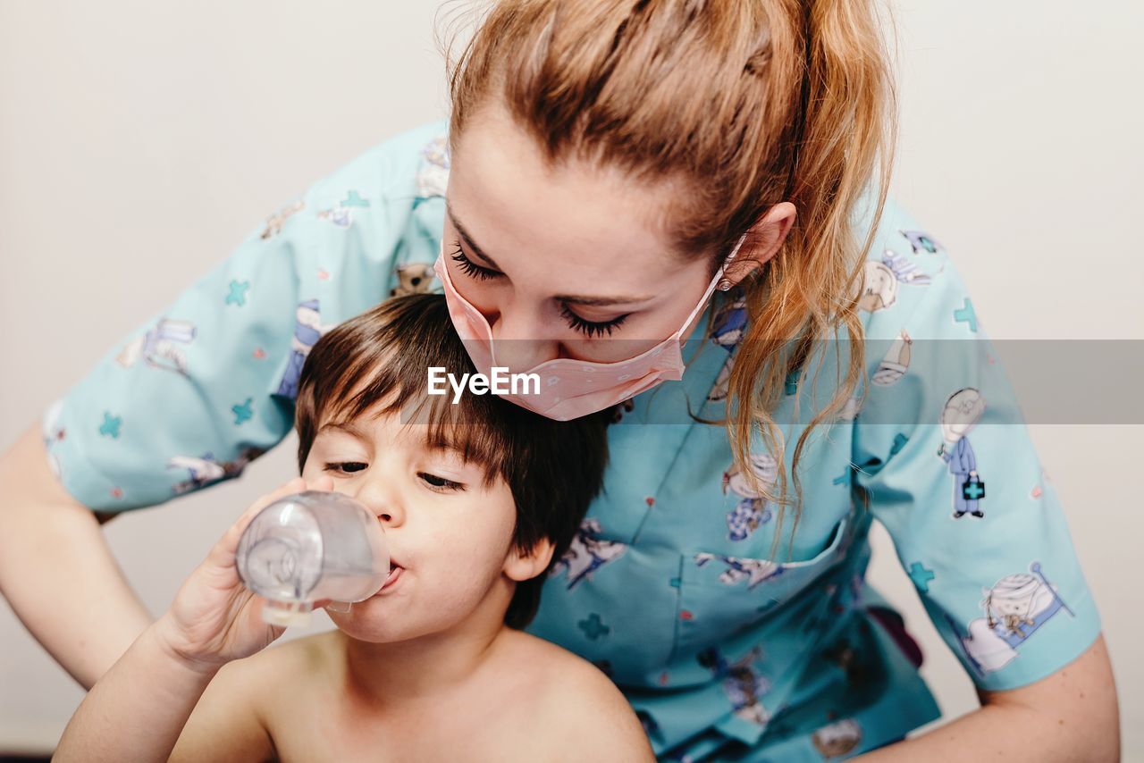 Little kid using inhaler in clinic during check up