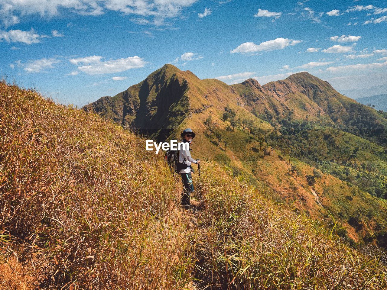 rear view of man walking on mountain against sky