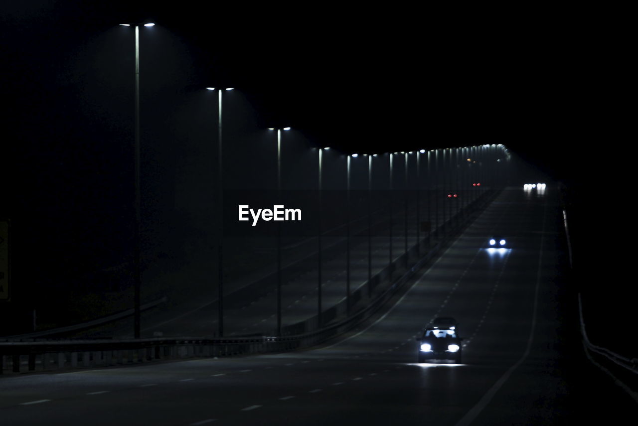 Illuminated street lights on road at night