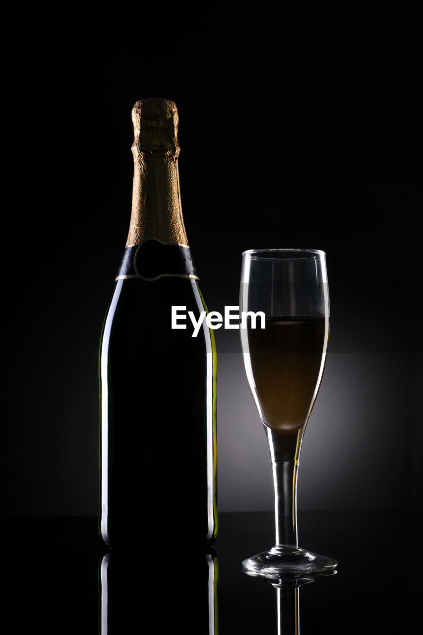 Close-up of champagne on table against black background