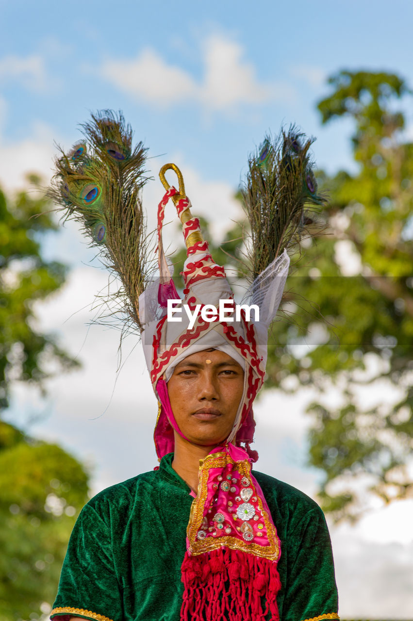 Portrait of bridegroom standing against sky