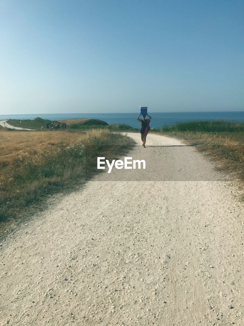 REAR VIEW OF MAN WALKING ON BEACH