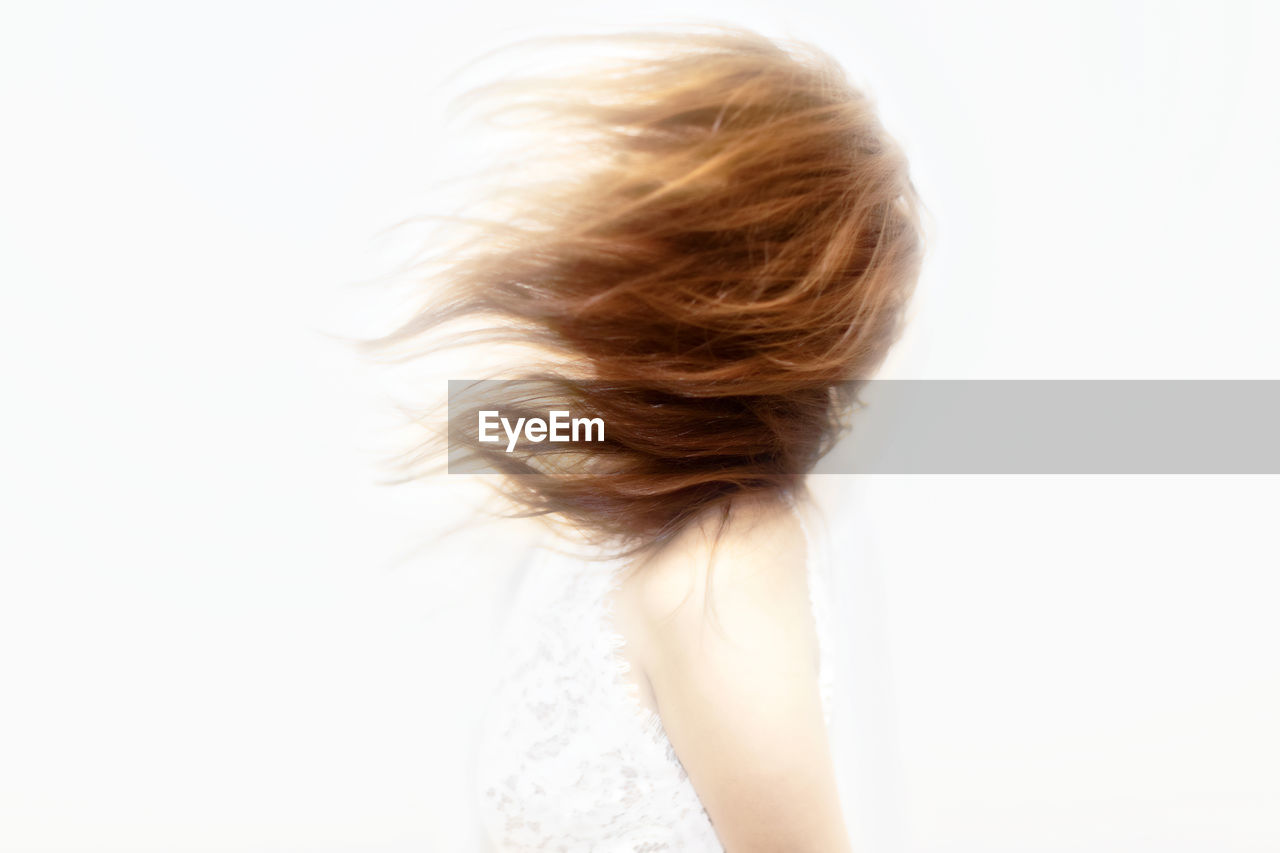 Side view of redhead woman against white background