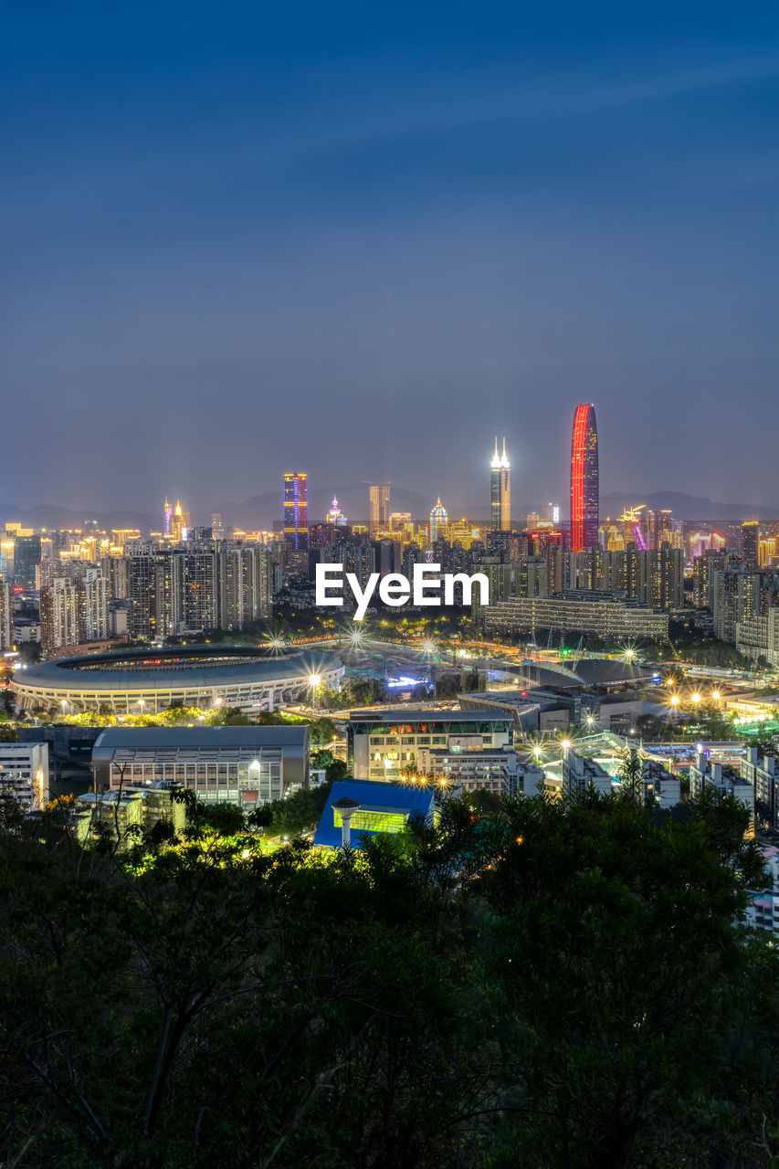 ILLUMINATED BUILDINGS IN CITY AGAINST SKY AT NIGHT